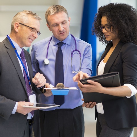 Group of healthcare workers discussing a project in the hallway
